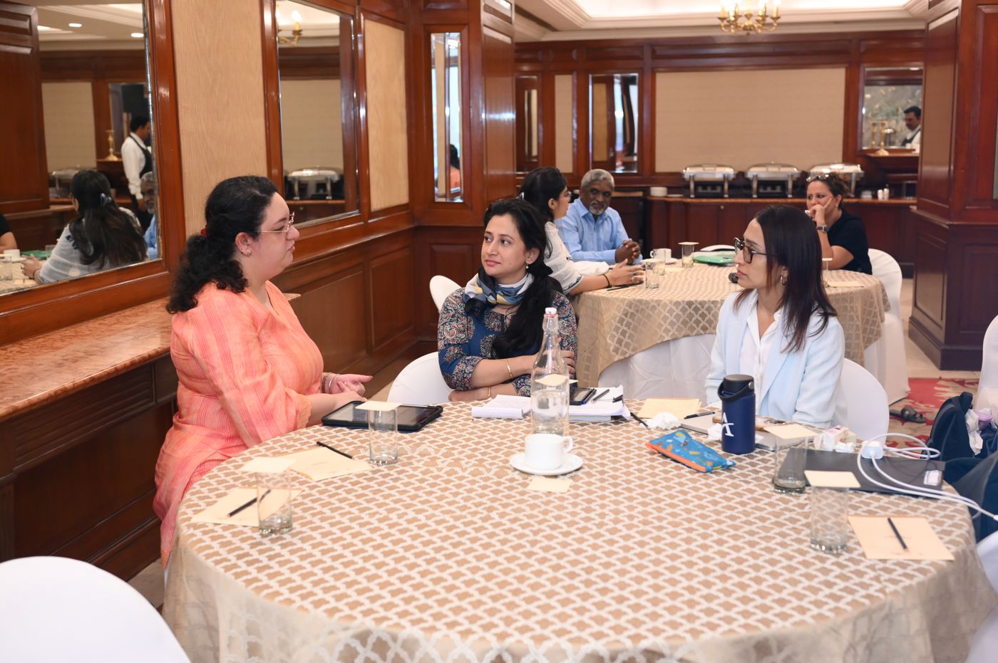Three participants in discussion at their table